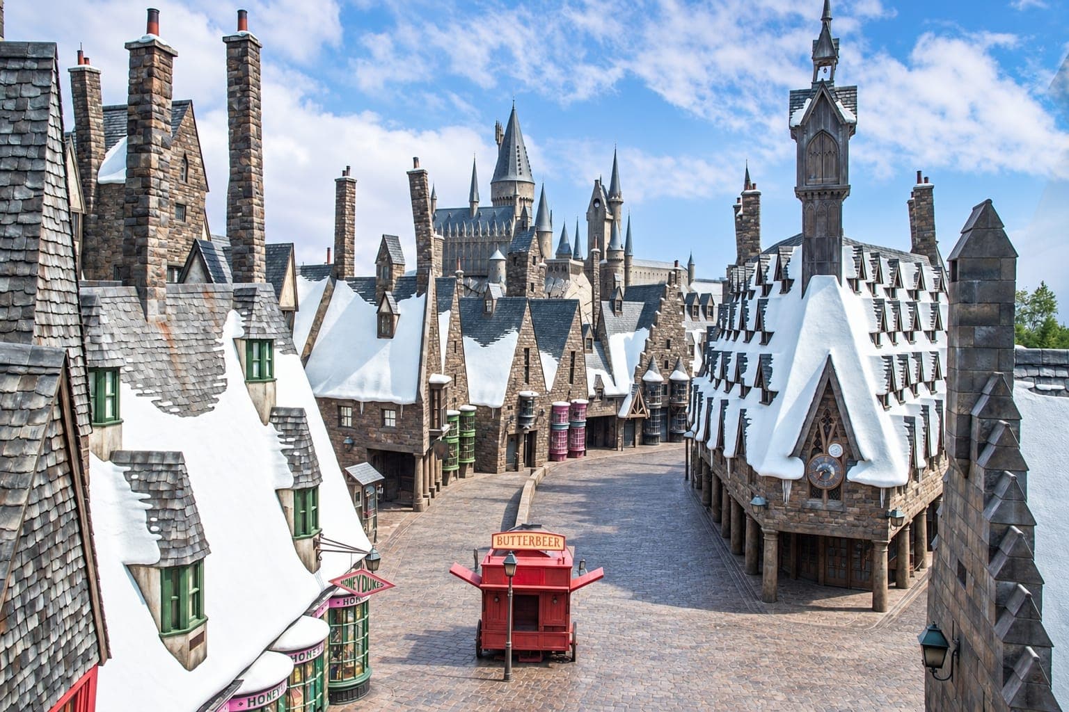 La calle de tiendas de Hogsmeade, sus tejados nevados y el castillo de Hogwarts en Universal Studios Japan, Osaka